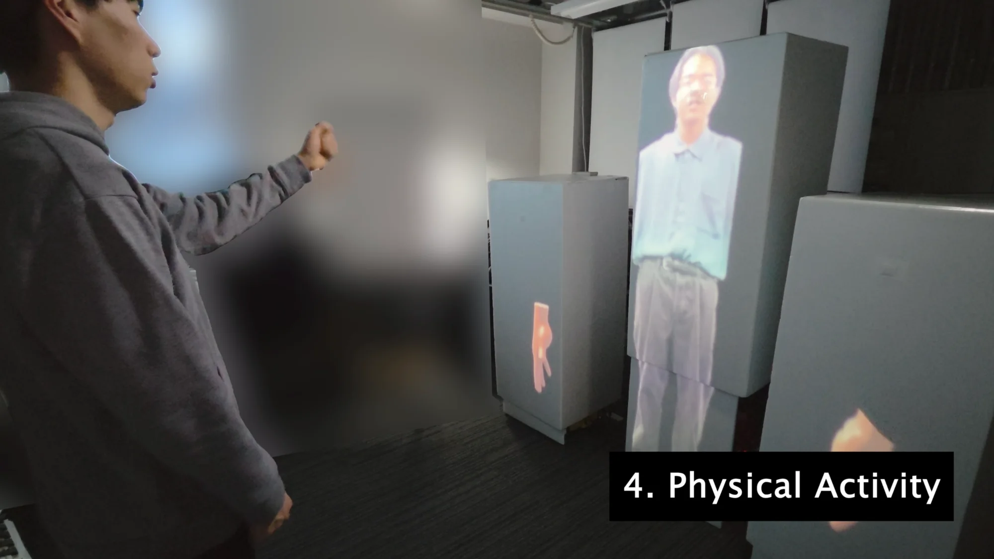 A participant interacting with a projected remote speaker across modular robot bodies